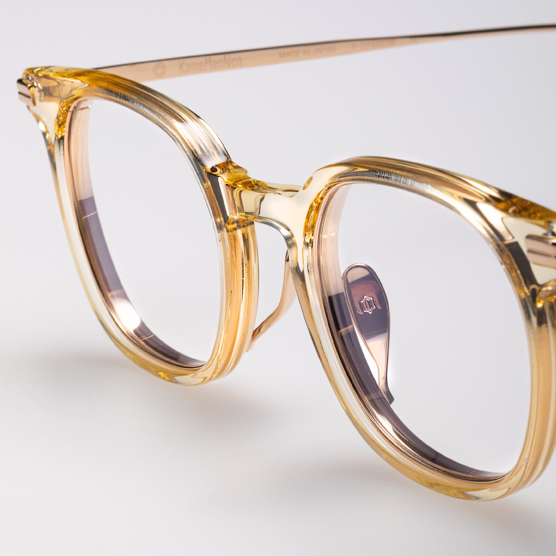 Gold-framed eyeglasses on a light gray background